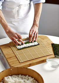 Hold the edge of the sushi mat