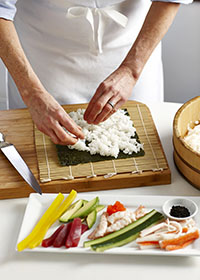 Bamboo sushi mat with nori sheet and rice